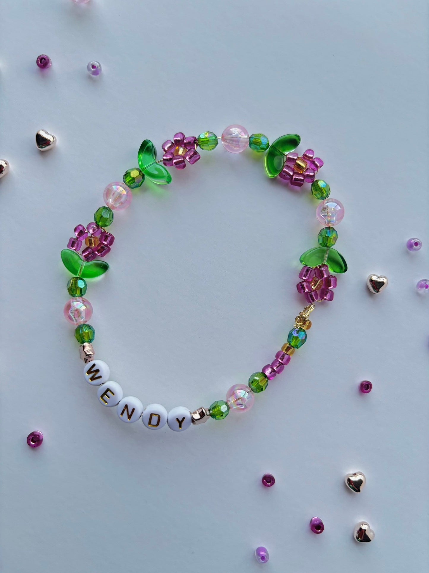 Personalize a vibrant beaded bracelet adorned with flowers. Customize it with your choice of name, word, initial, or letter.
