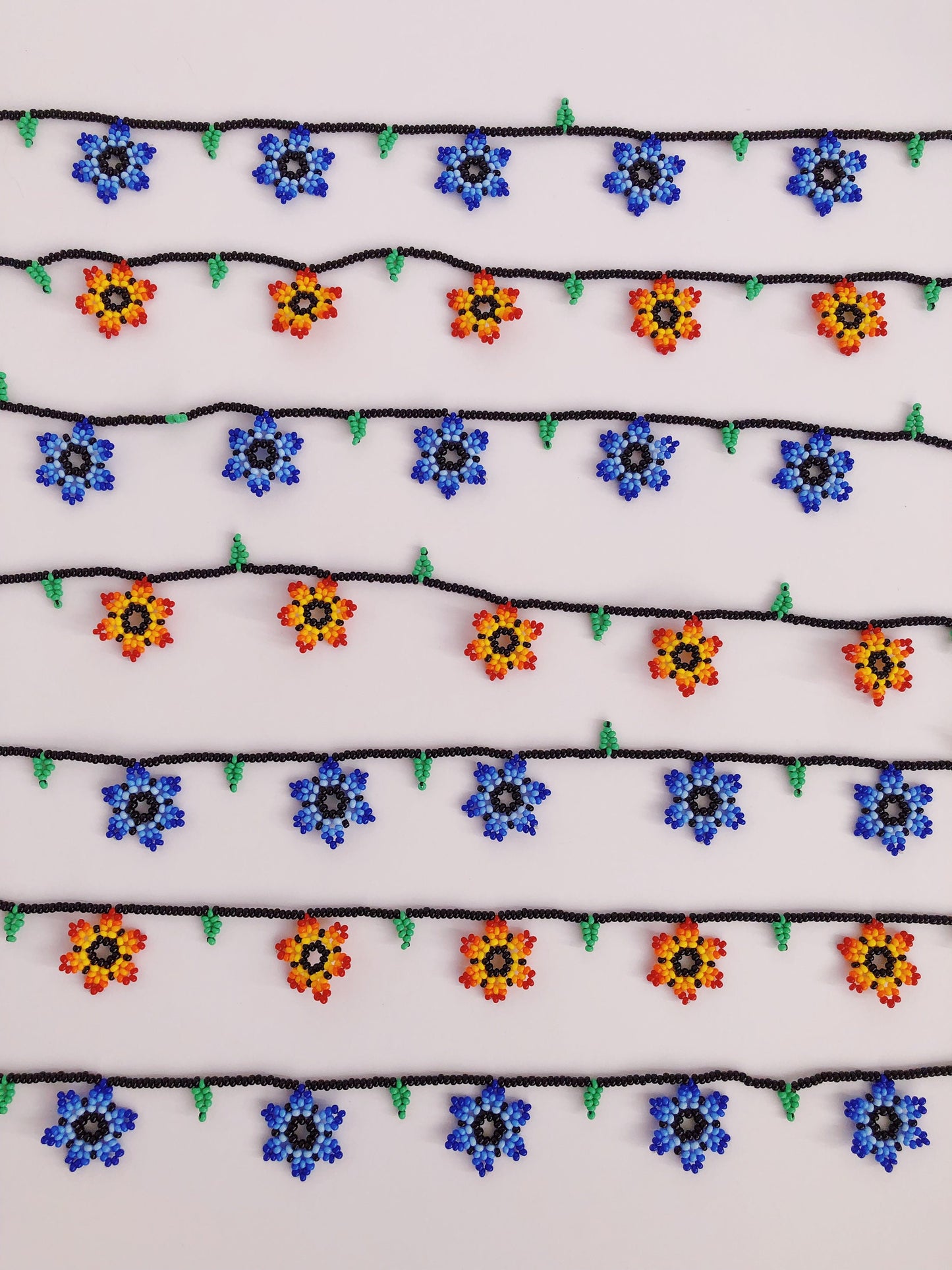Collares de cuentas con flores azules y naranjas