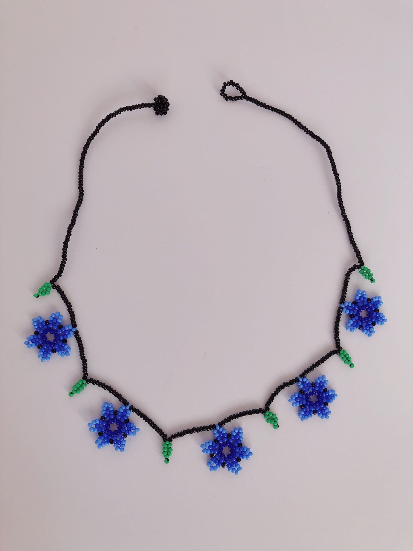 Collares de cuentas con flores azules y naranjas