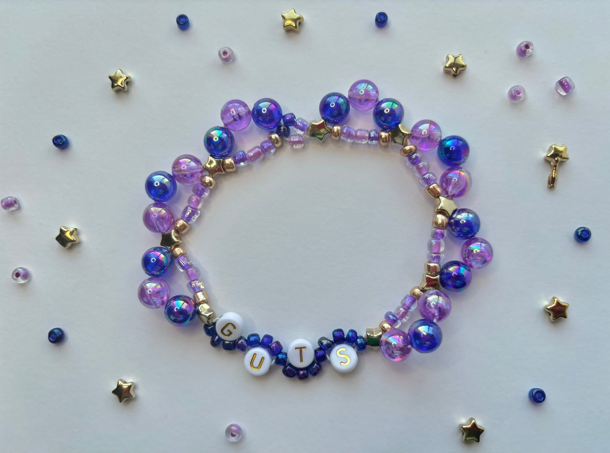 Olivia Rodrigo GUTS beaded bracelet decorated with butterflies, stars, lettering and purple beads.