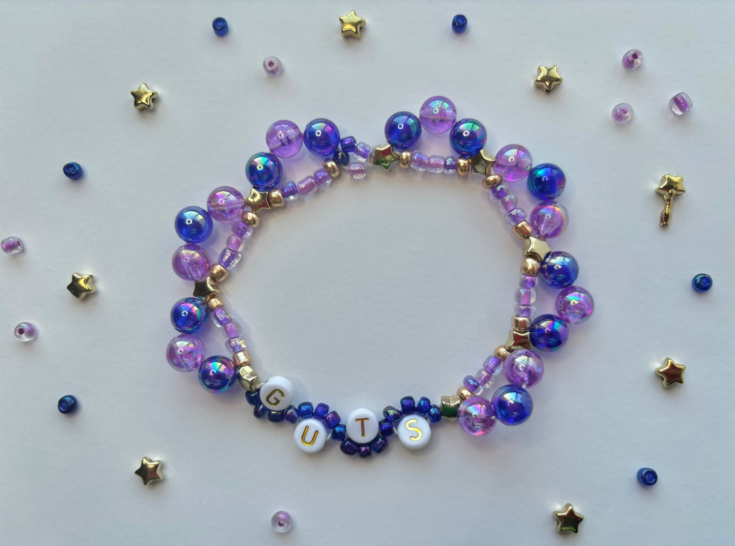 Olivia Rodrigo GUTS beaded bracelet decorated with butterflies, stars, lettering and purple beads.
