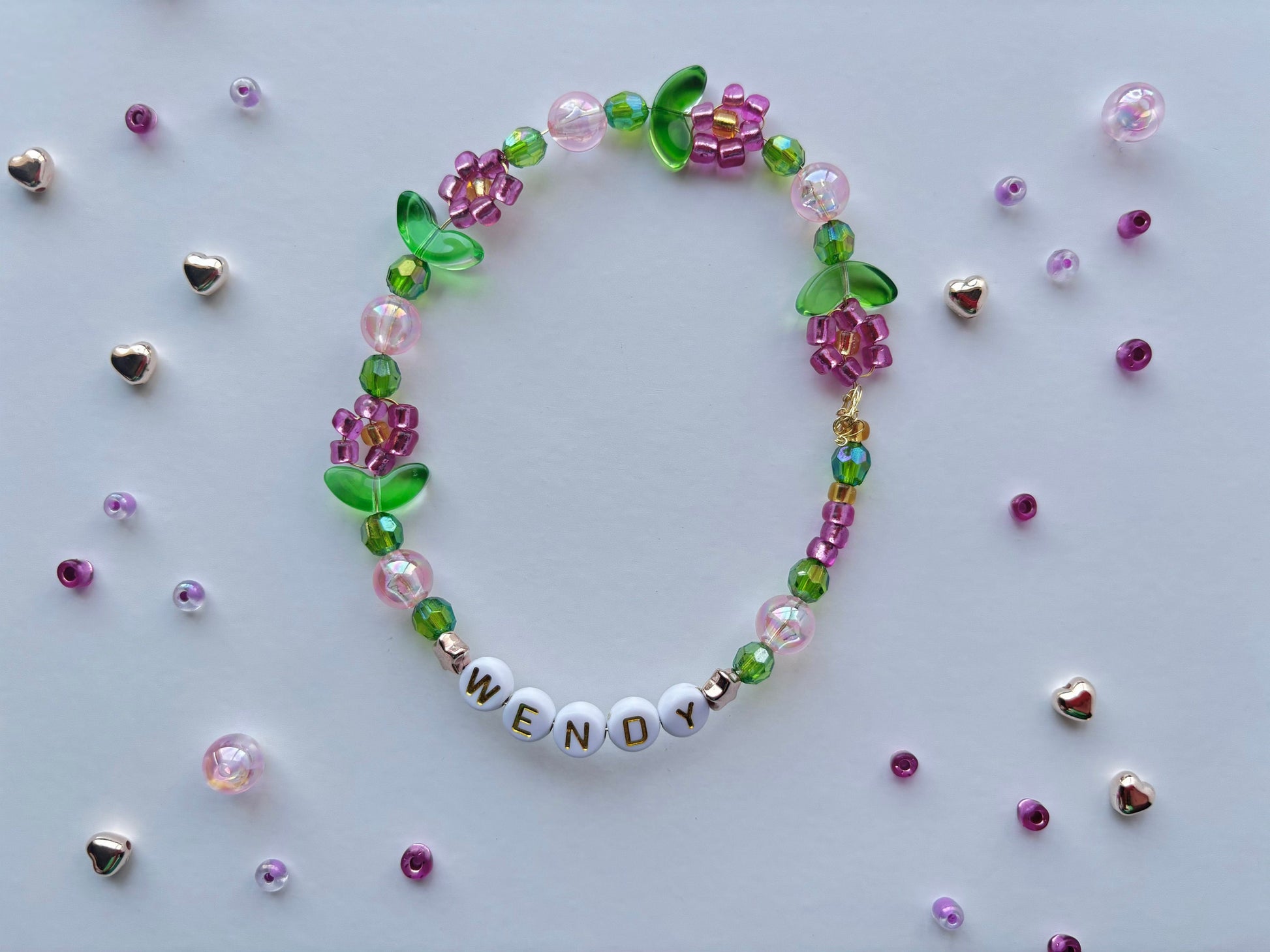 Personalize a vibrant beaded bracelet adorned with flowers. Customize it with your choice of name, word, initial, or letter.