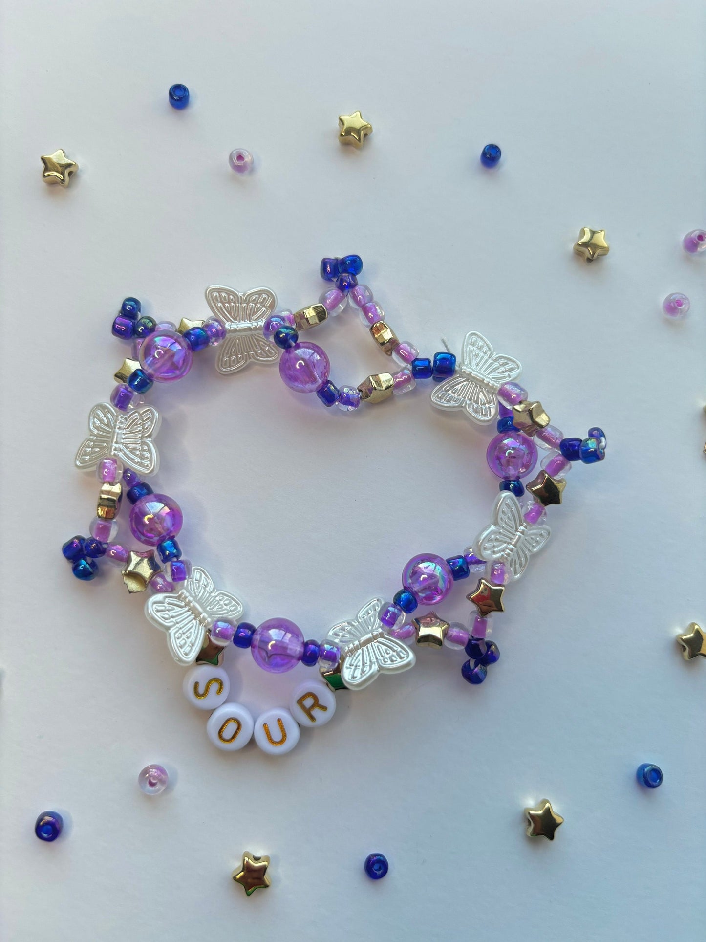 Olivia Rodrigo SOUR beaded bracelet decorated with butterflies, stars, lettering and purple beads.